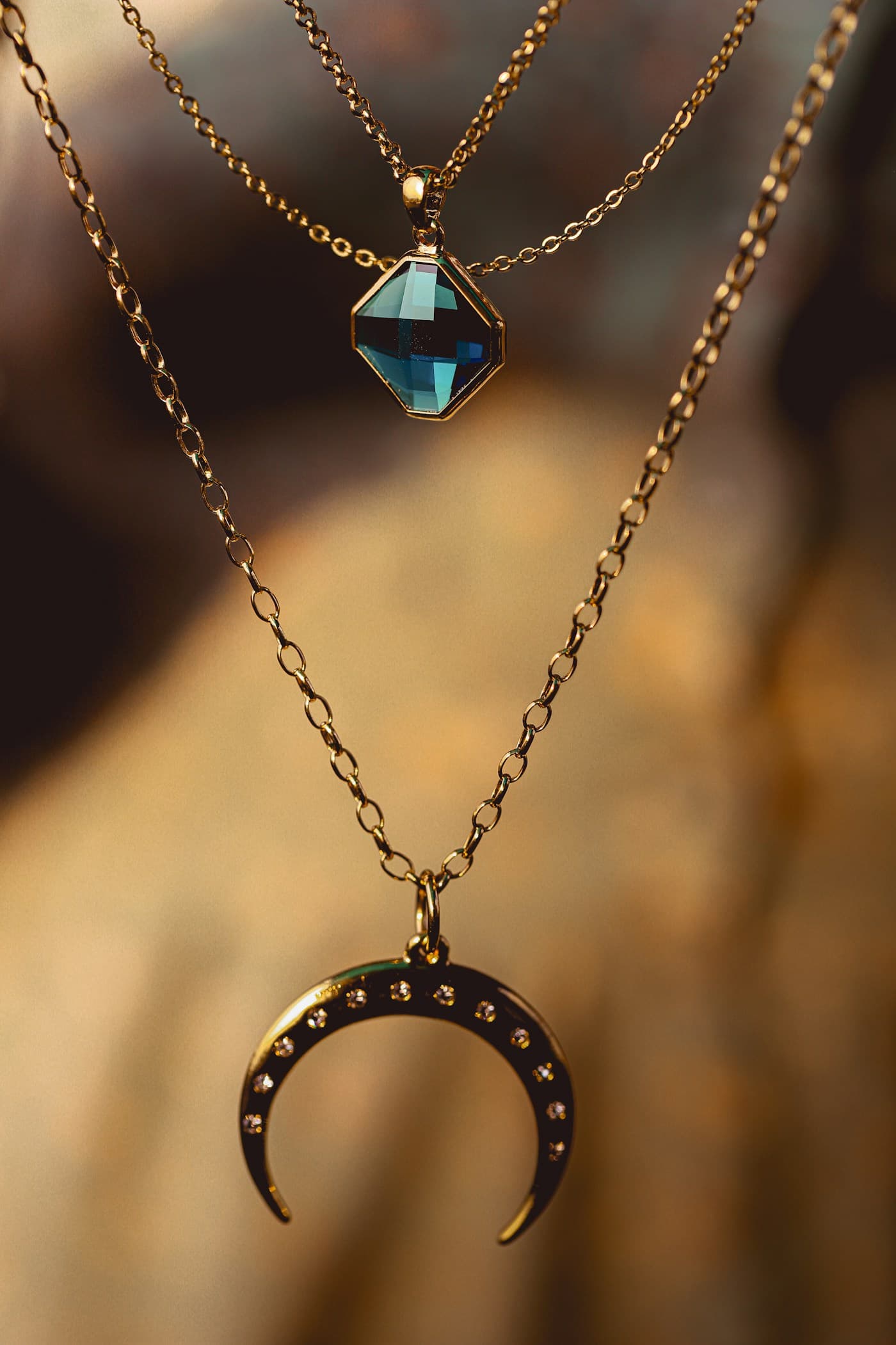 Layered gold necklaces with blue pendants