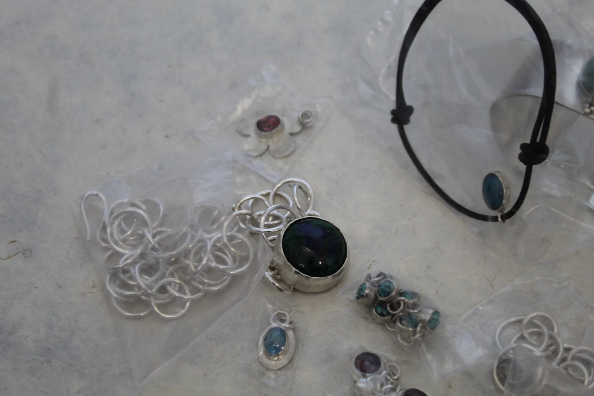 Silver necklaces and small objects arranged as a collection