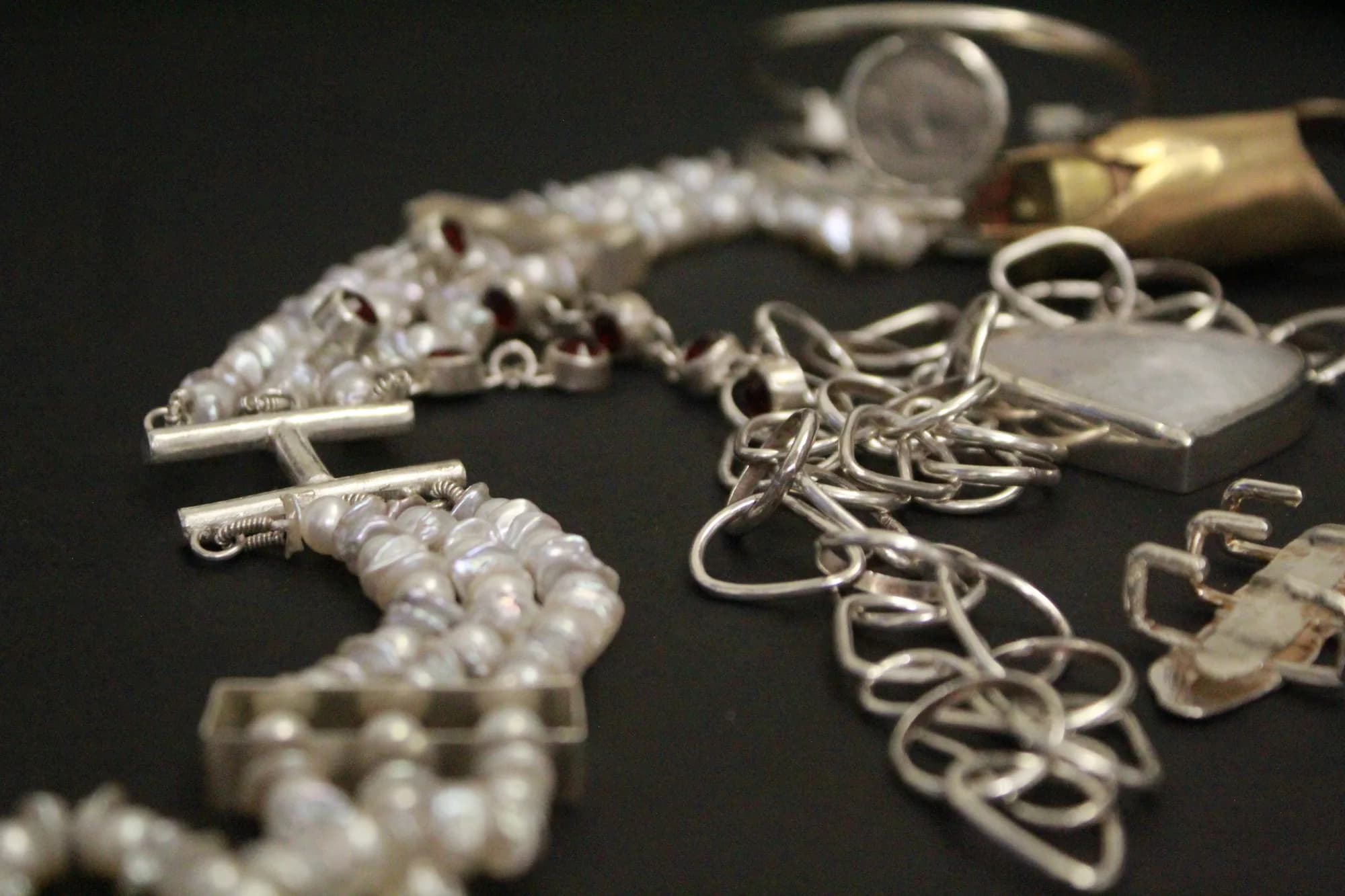 A dense cluster of silver chains and handmade jewelry