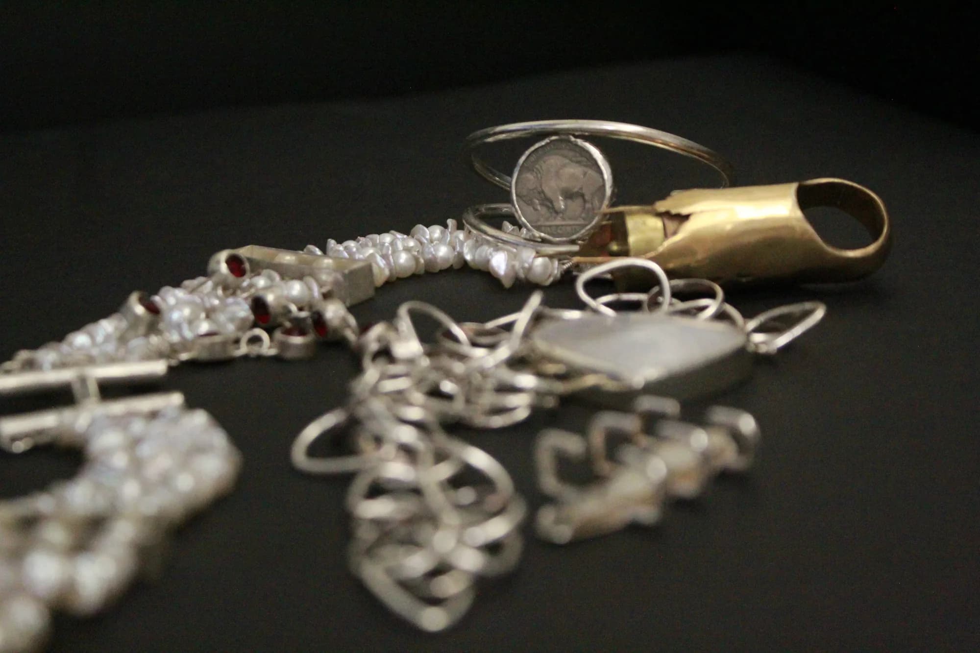 Handmade silver jewelry gathered on a dark background